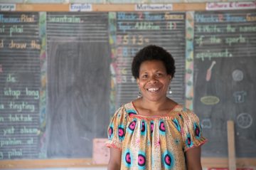 Naomi has been a teacher in her hometown of Ukarumpa for almost 20 years. She has always been passionate about education, and for girls in particular. She recently received training through CAREs Better Governance for Education project to teach her the best way to tackle high illiteracy rates in rural areas. The subject she now teaches to Prep aged children, called Jolly Phonics, is enhancing the way young children learn to read and write. .
NAOMIs story in her own words
I am Naomi. I am 36 years old.
Im married, I have three children, Laverdy (f 12), Shelomith (f, 9) Jeremiah (m, 7). Laverdy wants to be a doctor. And she is well on the way to achieving it. She gets good grades. She is in secondary school.
My husband is from Bougainville. Hes a plumber. His name is Leslie. Hes 43. 
Ive been a schoolteacher almost 20 years now. The job has changed very much over that time. I love my job. I see improvements in my teaching. And I enjoy seeing my former students graduate from higher institutions.
When I started I only had 19 students in my class, but in 2018 I have 36 students in my class. Thats a big change. Its still small compared to other schools though.
I decided to become a teacher when I was little; around six years old. I love it. I like talking to people and getting to know people. I had many teachers who inspired me, and Im sure they made me want to be a teacher. But also, I grew up here. I finished tenth grade in 1997, and I started a daycare centre here. And when elementary education was introduced, I took the six week training and then came back to teach those children. I was very excited by that opportunity. 
I grew up here. This is my home, my community. I want to teach and support people in my community here.
When CARE came in, that was very special.
Sometimes the preps have to walk a long way. Sometimes they find it hard to come to school.
The government is wanting all the schools in the country to teach phonics, so learning Jolly Phonics was a new thing for me and CARE provided me with materials for the new curriculum to help me teach, and taught me new teaching skills. I learned how to teach Jolly Phonics to children. We also get refresher training as well. This is all new, and most of the teachers from the village dont have access to knowledge or resources like this. 
After the training, my teaching style changed very much. I was able to take my resource books and adjust the lesson plans to suit the students in my community better. 
The training I received from CARE was very, very good. I wish there were more trainers to help overcome the low literacy in the country, to help our students. There should be more Jolly Phonics teachers.
I grew up here. This is my district, I want good results. Thats why I am happy that CARE trained me, to improve those results. Now I am also a trainer. I will teach other teachers the best way to teach Jolly Phonics. 
Children are more interested in the way the teachers are presenting lessons to them than in the content. So teachers must change the way we present lessons to the children to keep them interested.
The parents must help their children at home as well. Parents must spend time with their children to work on their homework as well. I see that as very important. Its more important than getting them to do the household chores or farming.
In our culture, boys are the head of everything. But girls are just as good as boys, and we do lots of work too. Its important to develop and change the way things have always been.
A well-educated woman will be more respected in the community. All women in the village should be respected but because of the culture, a woman who isnt educated wont feel respected. [Other people will] say bad words about her. Theyll make her feel bad. Like shes not doing what her parents ask her to do. They wont value her opinion on things.
The girls show more promise than the boys even at Prep. I encourage the girls. I tell them that they can be someone better than I am. If they dont have that kind of encouragement they might not come to school. 
If they dont come to school, I call the parents and ask them why they are keeping their child at home. And I share their progress with the parents to keep them involved and to help them see how important it is that their child stays in school.
A lot of people in PNG are illiterate. Thats a big problem we see in school, especially in written exams at secondary school. And the fingers are being pointed at elementary school teachers like me. And I am very cross with this. So my desire is to have more training and grow further.
There needs to be more schools for the children who are left out. There needs to be more teachers trained and more funding given to schools. CARE has funded some remote schools, funded building their modern buildings, sponsored teachers.
Thank you so much for taking the initiative to come into our remote communities. Its the governments responsibility but you have done it. And I am looking forward to you sponsoring more teachers, and you will see success.
Interviewed by JOHN HEWAT in UKARUMPA on 18/07/2018.
Project information and scene setting information:
Children in PNG, especially girls from remote communities, experience profound challenges to getting a quality education. CARE links government and remote communities to develop joint action plans for schools that aim to meaningfully include women and girls. By strengthening community governance and sharing decision-making processes more equally, we see better education outcomes for all. CARE is also supporting Government Education Officers to train teachers and conduct supervisory visits, and is providing teaching aids and learning materials like books, stationery and phonics learning kits.