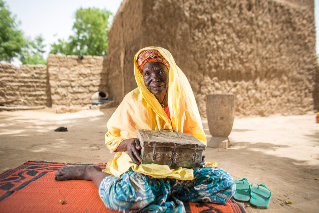 Zeinabou a 90 year old woman holding a VSLA lock box